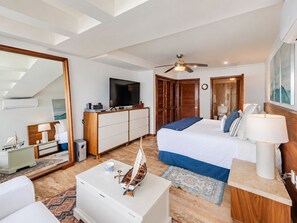 Et hotelværelse med seng, fjernsyn, skrivebord, garderobeskab og ventilator.