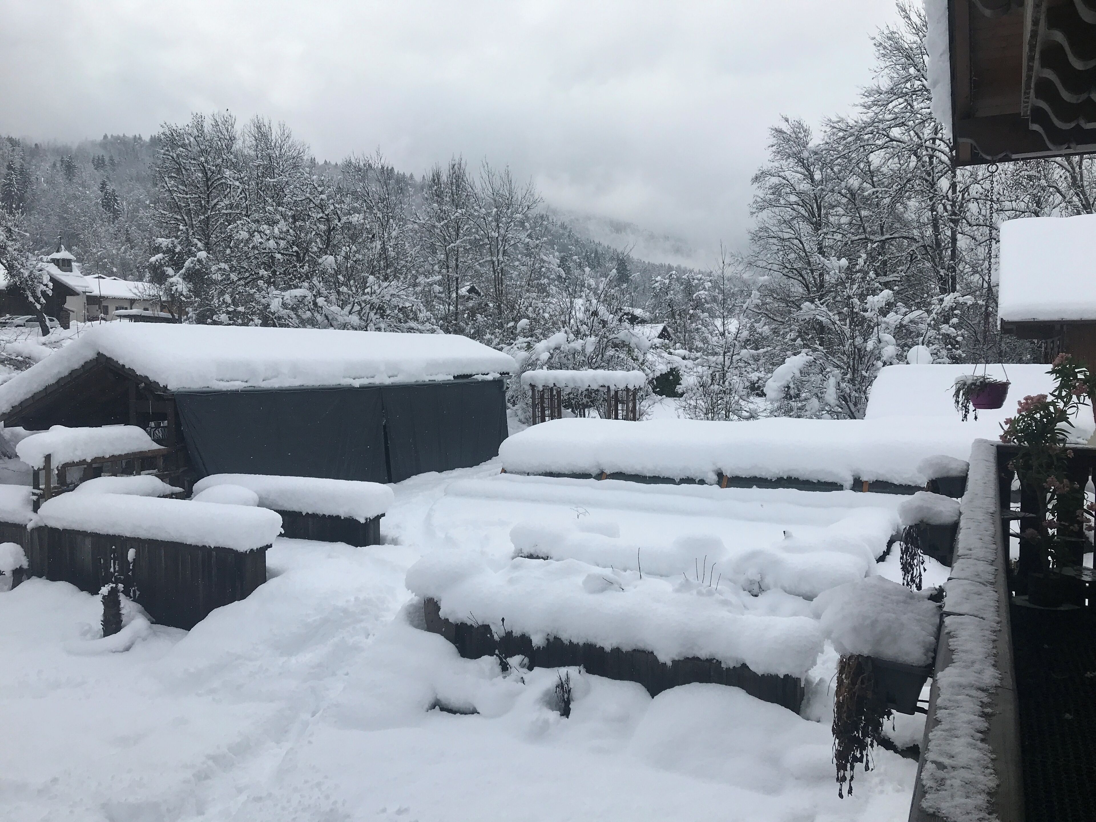 Ein verschneites Dorf mit traditionellen Häusern und einer Bergkulisse.