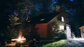 A rustic cabin with a sloped roof, a visible chimney, and a small porch area. - Stonebridge Cabin: Modern Amenities, Enjoy Nature! (Lee)