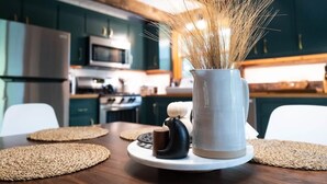 A kitchen with teal cabinets, a microwave, and a stainless steel refrigerator. - Stonebridge Cabin: Modern Amenities, Enjoy Nature! (Lee)