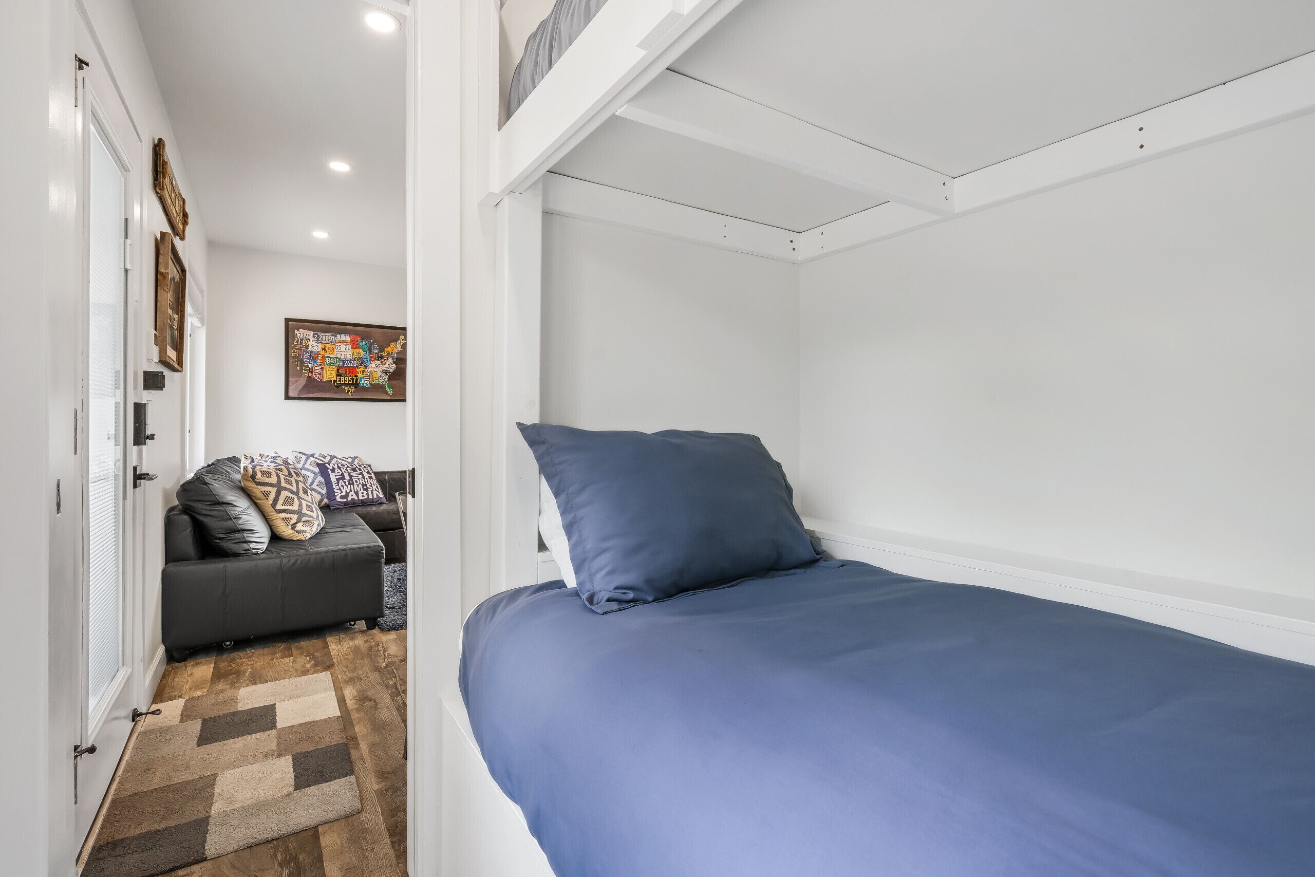 Un dormitorio con una cama individual, un sofá y un tapete estampado.