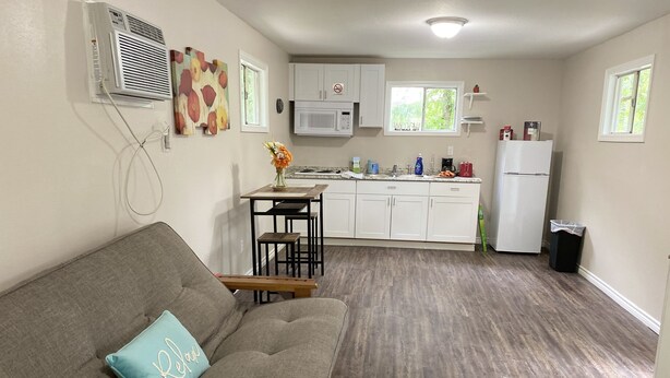 A compact living space with a sofa, a dining table, and a kitchenette. - Great Place to Relax! (Cleveland)