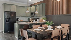 A modern kitchen with a central island, dark wooden cabinets, and pendant lighting.