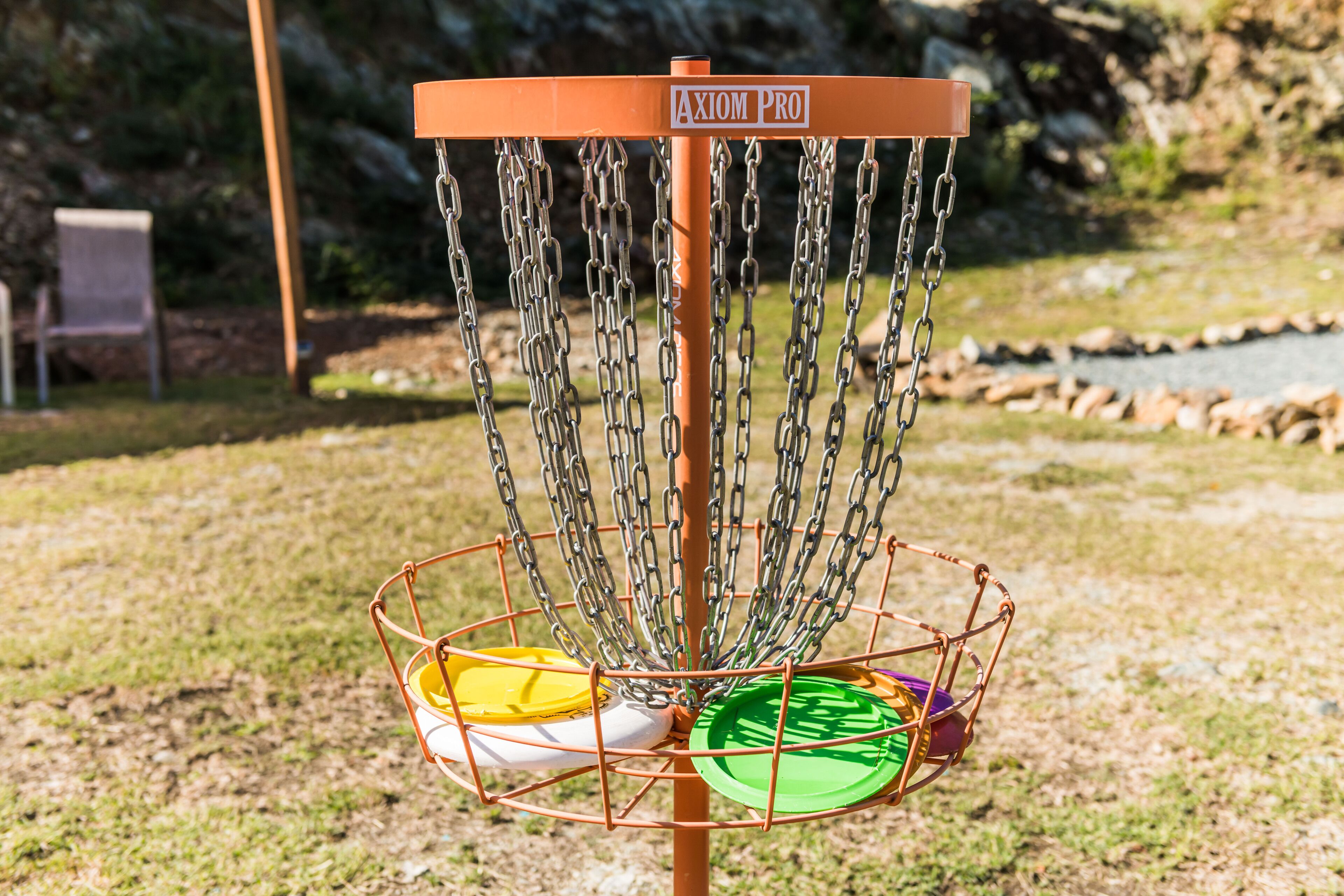 A disc golf basket with multiple chains and a sign labeled "Axiom Pro".