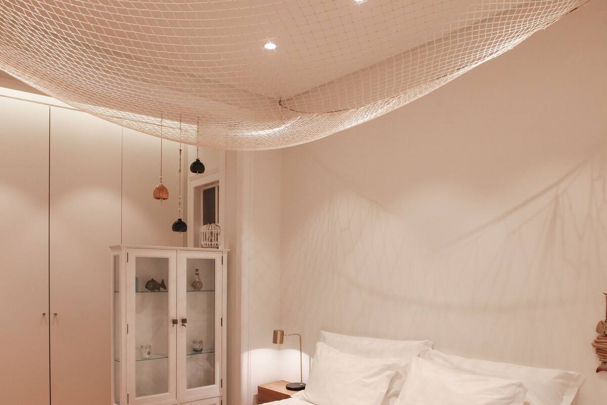 A bedroom with a large bed, a wardrobe, and a cabinet.