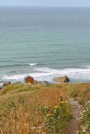 A coastal path leading to a small wooden structure by the sea. - Tregantle Farm Eco Glampsite Super Safari Cabin (Torpoint)