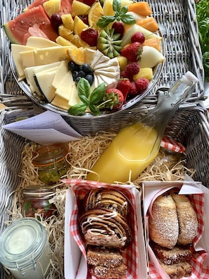 A breakfast buffet with a variety of fruits, cheeses, and pastries. - Tregantle Farm Eco Glampsite Super Safari Cabin (Torpoint)