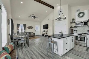A spacious kitchen with a large island, white cabinetry, and stainless steel appliances. - Hill Country-Fire Pit & Hot Tub! (Fredericksburg)