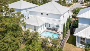 A residential area with multiple houses, a swimming pool, and a well-maintained lawn. - Stella Maris- Updated Home, Heated Private Pool, Walk to the Beach + Gulf Place! (Santa Rosa Beach)