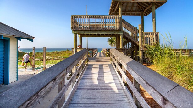 A wooden boardwalk leading to a beach area with a small building and a lookout tower. - Stella Maris- Updated Home, Heated Private Pool, Walk to the Beach + Gulf Place! (Santa Rosa Beach)