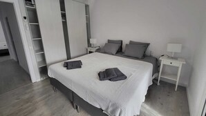 A bedroom with a bed, two bedside tables, a ceiling fan, and a wardrobe with a mirror. - Charming villa with swimming pool, very well equipped and 900m from the beach (Torredembarra)