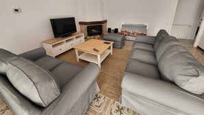A modern living room with a sofa set, a TV, a coffee table, and a fireplace. - Charming villa with swimming pool, very well equipped and 900m from the beach (Torredembarra)
