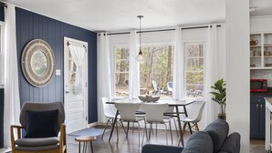 A dining area with a table and chairs, a sofa, and a potted plant. - Private + Wooded + Quaint & Cozy + 5 mins to Dwntn Blk Mtn + 15 mins to Ashvle (Black Mountain)