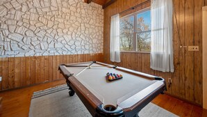 A pool table in a room with wooden walls and a stone accent wall. - 🍁CLOSE TO GATLINBURG & PIGEON FORGE W/POOL TABLE🎱 (Gatlinburg)