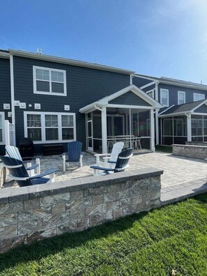 Una casa con patio, mobiliario exterior y una sección cubierta.