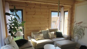 A cozy living room with a sofa, a coffee table, and a potted plant. - Haus Seeblick, directly on the shore of the Gr. Lake Zechlin (Rheinsberg)