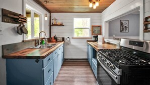 A kitchen with wooden cabinets, a stove, and a window.