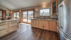 Una cocina moderna con armarios de madera, un refrigerador de acero inoxidable y una isla grande.