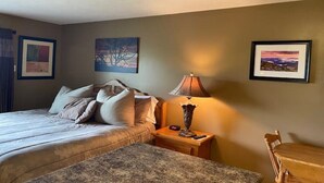 Une chambre à coucher avec un lit, une table de chevet, une lampe et une chaise.