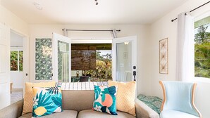 A modern living room with a sofa set, a chair, and a view of the outdoors. - Jungle Bungalow - A lovely space to stay for island fun! (Keaau)