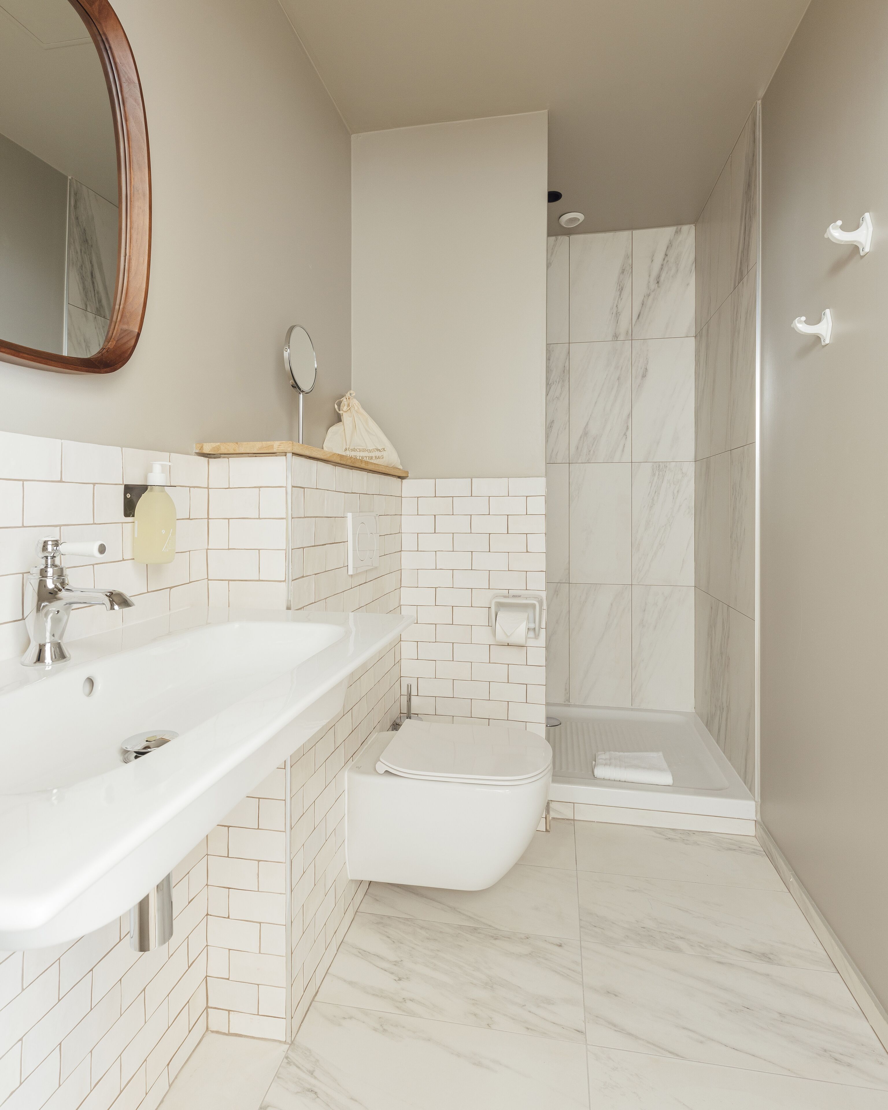 A modern bathroom with a large sink, toilet, and shower area.