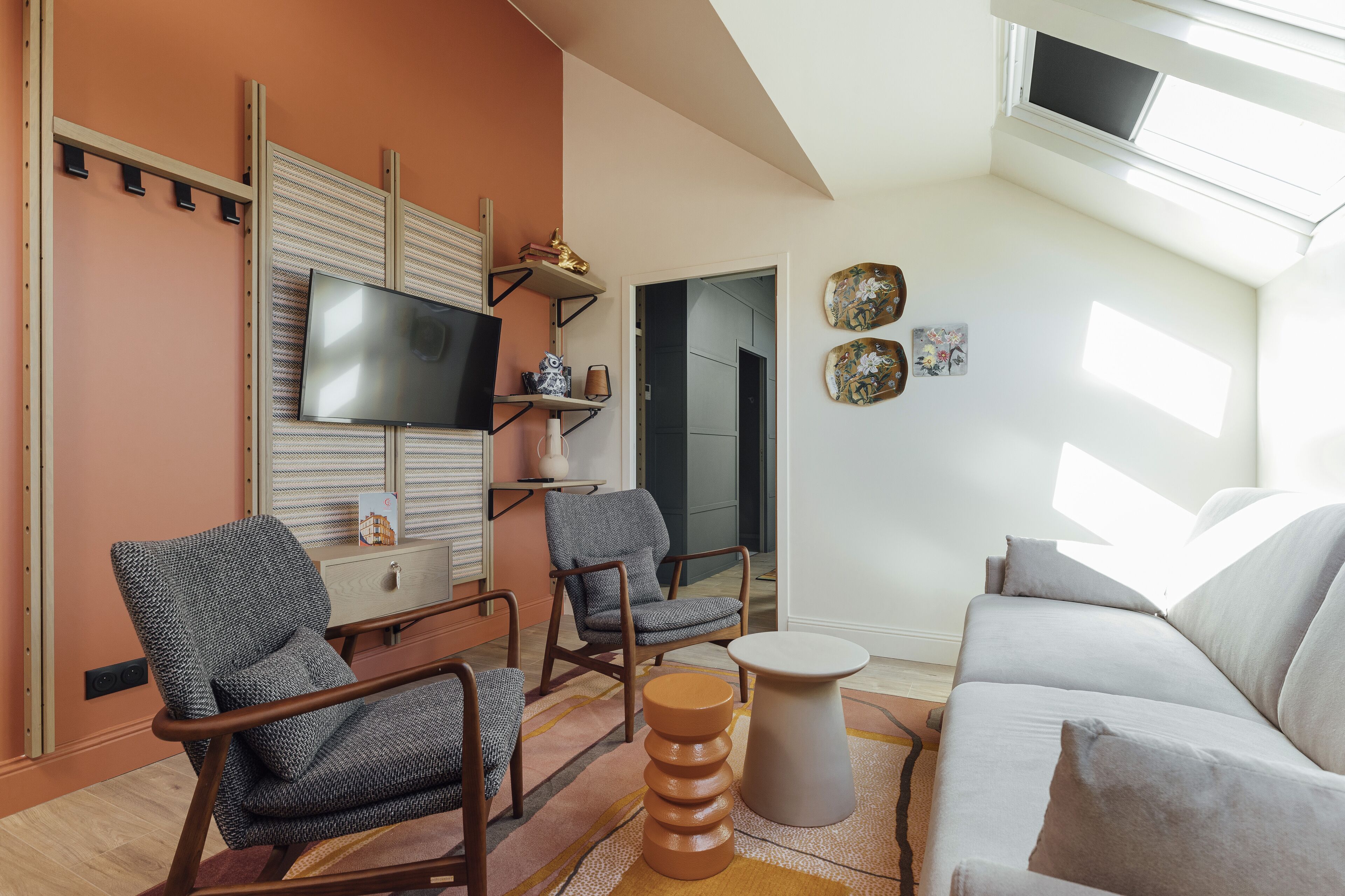 Una sala de estar moderna con un sofá, dos sillones, un televisor y una mesita.
