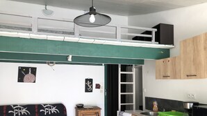 A compact kitchen with wooden cabinets, a small refrigerator, and a coffee machine. - 1 Bedroom Apartment in Tresques (Tresques)