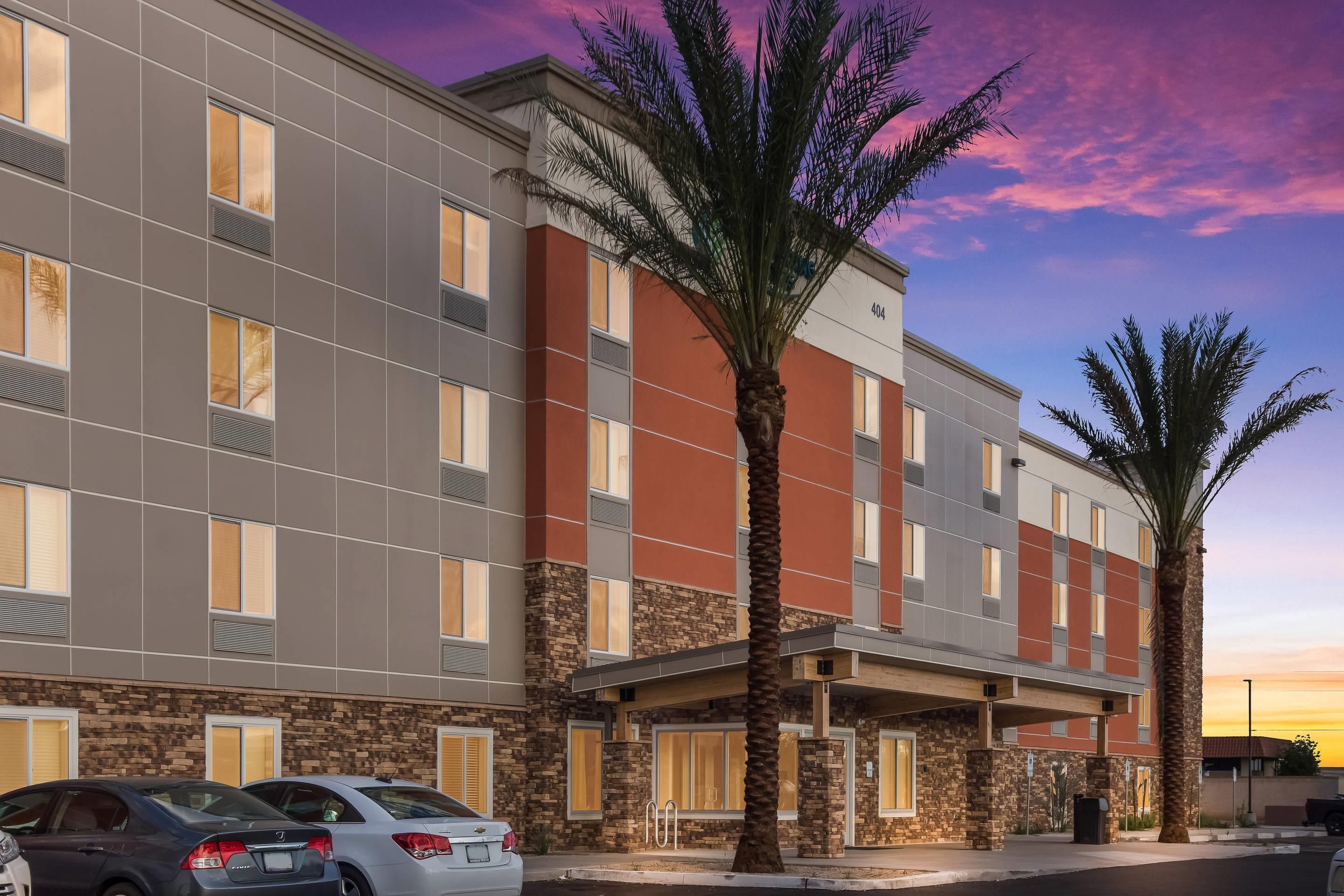 A hotel with a modern facade, multiple windows, and a covered entrance area.