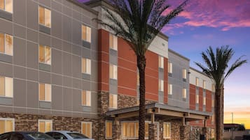 Un hotel con fachada moderna, varias ventanas y un área de acceso cubierta.