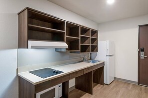 A compact kitchen with a built-in oven, a sink, and a refrigerator.