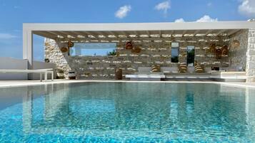 Een infinity pool, ligstoelen bij het zwembad