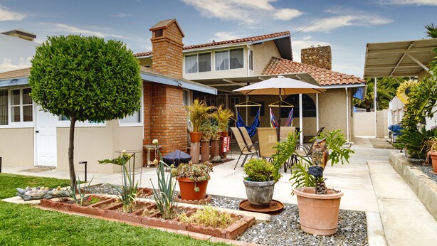 A residential house with a patio area, potted plants, and a small garden. - Quality Lodging by the Sea. Lovely full size apartment w/balcony and ocean view. (Ensenada)