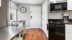 Cocina compacta con estufa, microondas y refrigerador.
