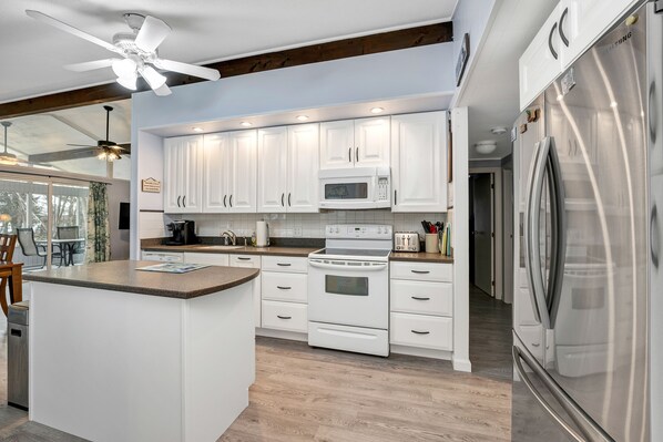 Enjoy cooking in this well-lit kitchen with a central island, microwave and oven, and stainless steel appliances.
