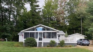 Una casa a un piano con un ampio portico, una veranda coperta e un garage.