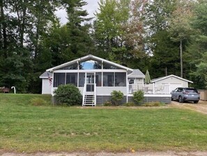 Guests can enjoy a porch and well-manicured lawn in this single-story home.