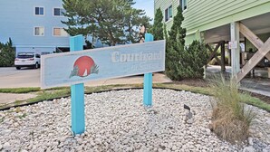 A sign for 'Courtyard at Seascape' with a beach scene illustration.