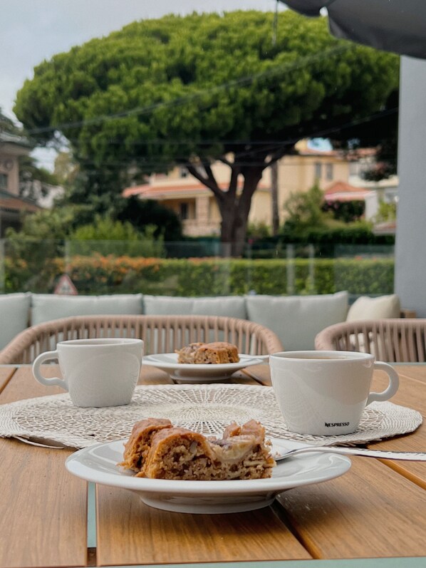 A table with a plate of food, a cup, and a saucer. - Luna House (Cascais)
