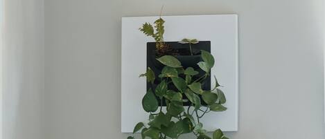 A desk with a plant, a lamp, and a bottle.