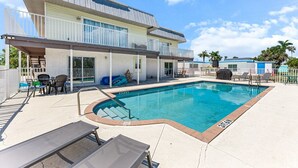 Ein modernes Gebäude mit Swimmingpool, Außenbereich und überdachter Terrasse.