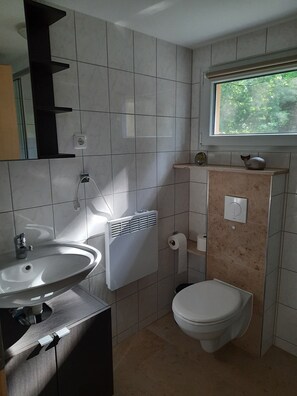 Une salle de bain moderne avec un lavabo, des toilettes et une fenêtre.