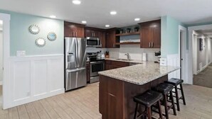 Una cocina moderna con una isla central, electrodomésticos de acero inoxidable y armarios de madera.