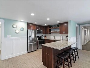Enjoy cooking in this well-lit kitchen with a central island and stainless steel appliances.
