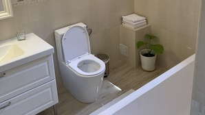 Ein modernes Badezimmer mit Toilette, Waschbecken und Badewanne.