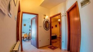 A hallway with wooden doors, a radiator, and a patterned rug.
