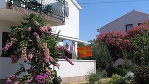 A modern two-story house with a balcony, a garden with flowering plants, and a paved driveway. - Apartment in Vodice with Seaview, Balcony, Air condition, WIFI (612-4) (Vodice)