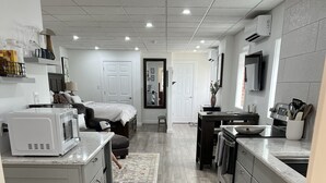 A modern kitchen with grey cabinets, a microwave, and a sink. There is a dining area with a table and chairs. - Step into downtown, 5 minutes drive to Luray Caverns, 15 to Thorton Gap entrance (Luray)