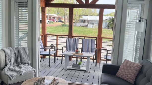 Ein geräumiger Wohnbereich mit einer Holterrasse, einem Sofa, einem Sessel und einem Couchtisch.