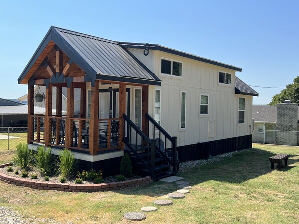 A two-story house with a covered porch and a small deck. - New Cozy Cottage on Lake Texoma (Kingston)