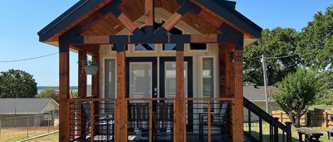 A small, single-story building with a porch and a covered deck area.